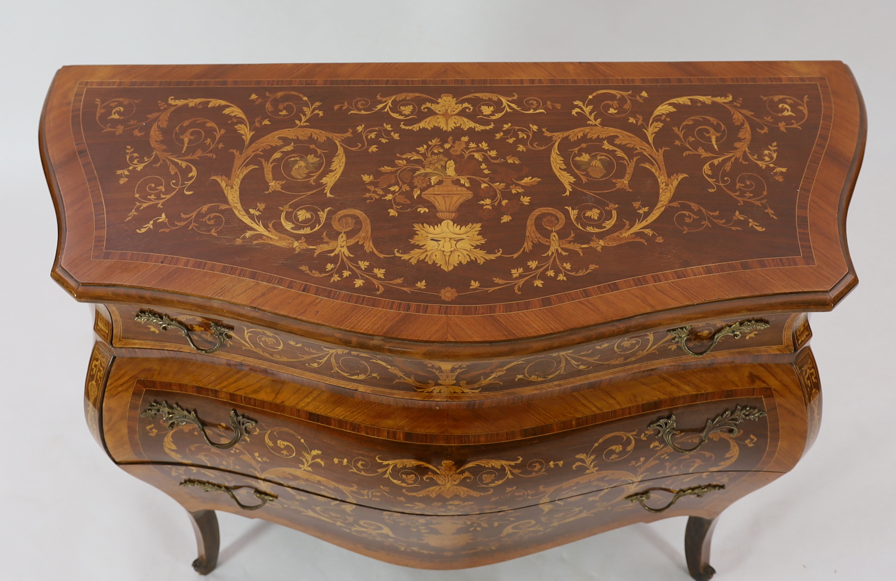 A Continental marquetry inlaid serpentine bombé commode, 130cm wide, 54cm deep, 94cm high